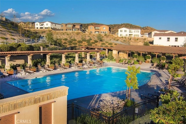 pool with a residential view, fence, and a patio