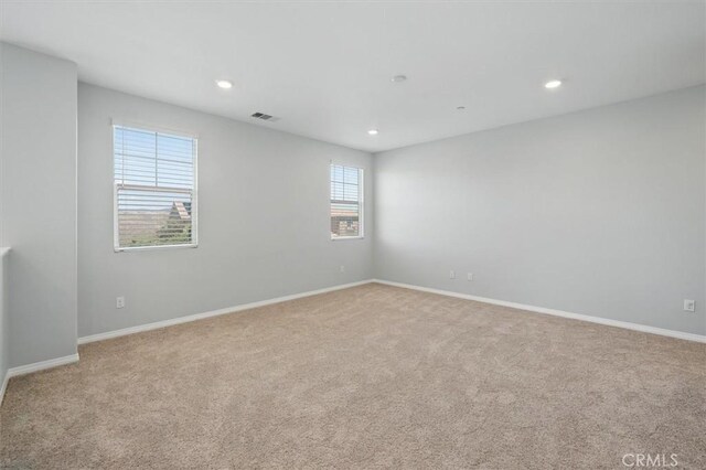 carpeted spare room with visible vents, recessed lighting, and baseboards