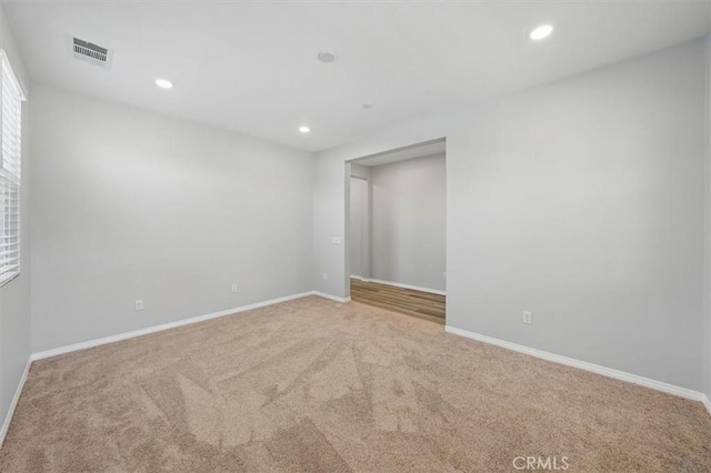 carpeted empty room with recessed lighting, baseboards, and visible vents