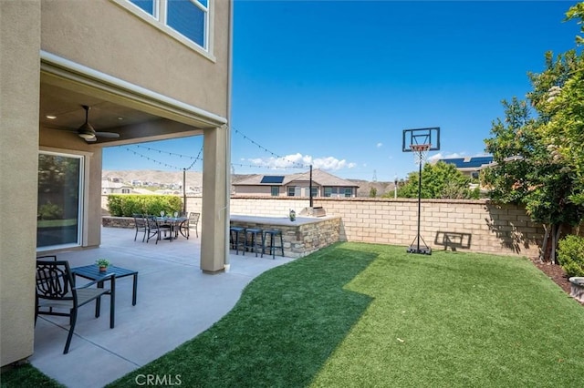view of yard featuring a patio, a ceiling fan, fence private yard, and outdoor dry bar