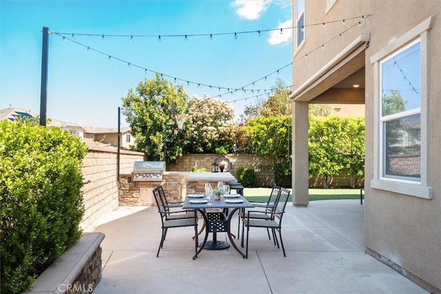 view of patio featuring area for grilling, grilling area, outdoor dining area, and a fenced backyard