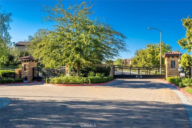 view of property's community featuring fence and a gate