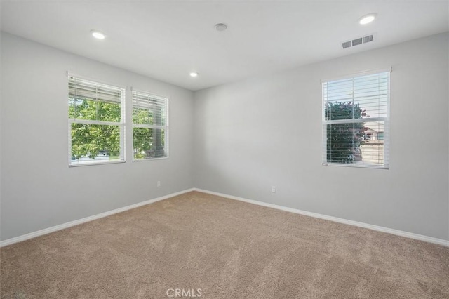 unfurnished room featuring visible vents, carpet flooring, baseboards, and recessed lighting