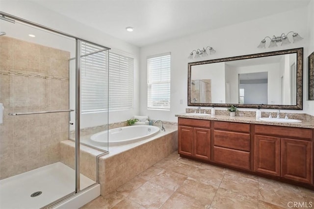 full bathroom with a sink, double vanity, a stall shower, and a garden tub