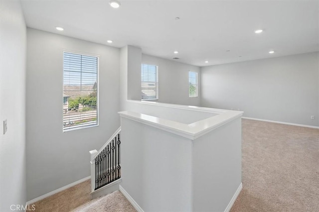 interior space featuring carpet floors, baseboards, recessed lighting, and a wealth of natural light