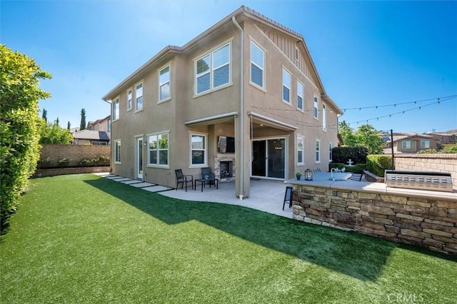 back of property with a lawn, a fenced backyard, a patio area, and stucco siding