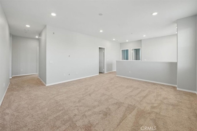 unfurnished room with recessed lighting, baseboards, and light carpet