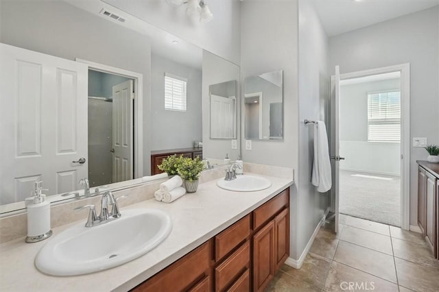 bathroom with double vanity, visible vents, a sink, and tile patterned flooring
