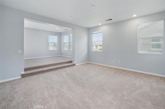 carpeted empty room featuring baseboards, recessed lighting, and visible vents