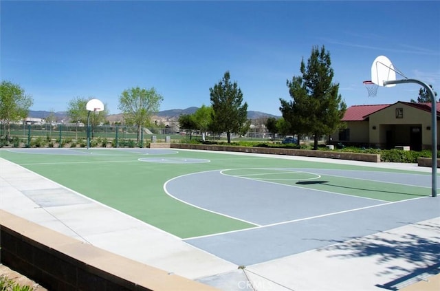 view of basketball court featuring community basketball court, fence, and a mountain view