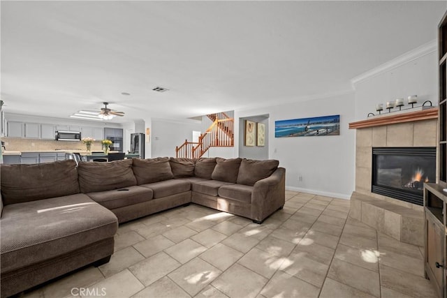 46140 Grace Ct, Temecula, CA 92592 - living area featuring stairs, a tile fireplace, a ceiling fan, ornamental molding, and baseboards