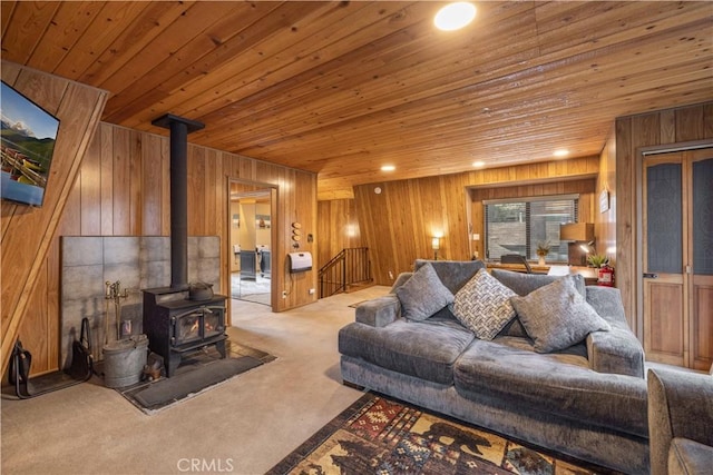 living area featuring wooden walls, a wood stove, carpet floors, recessed lighting, and wood ceiling