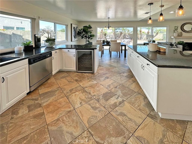 kitchen featuring stainless steel dishwasher, dark countertops, and wine cooler