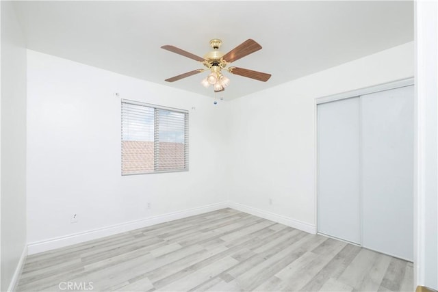 unfurnished bedroom featuring a closet, baseboards, a ceiling fan, and light wood-type flooring