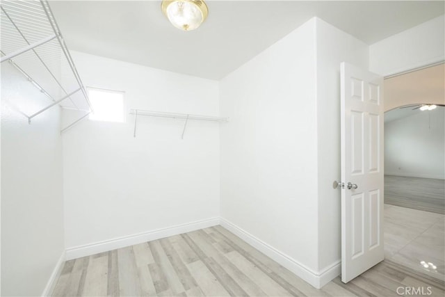 walk in closet with wood finished floors