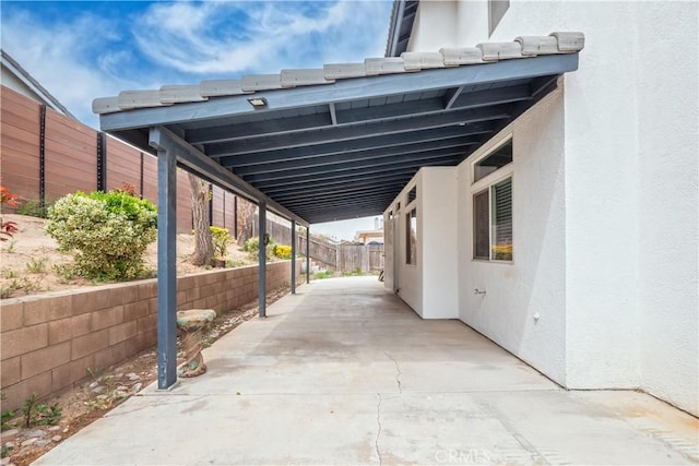view of patio / terrace featuring fence and an attached carport