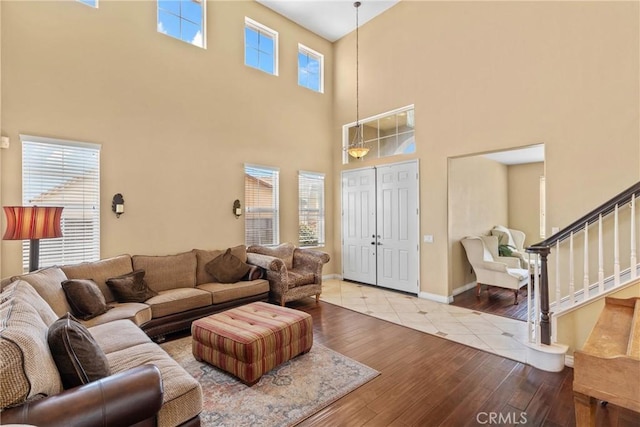 8309 Clover Creek Rd, Riverside, CA 92508 - living room featuring stairway, hardwood / wood-style flooring, a high ceiling, and baseboards