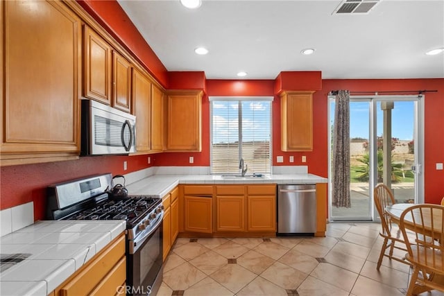8309 Clover Creek Rd, Riverside, CA 92508 - kitchen featuring stainless steel appliances, tile countertops, a sink, recessed lighting, and light tile patterned floors