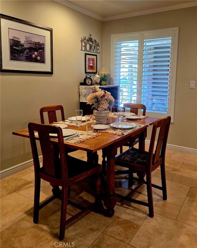 dining room featuring crown molding and baseboards