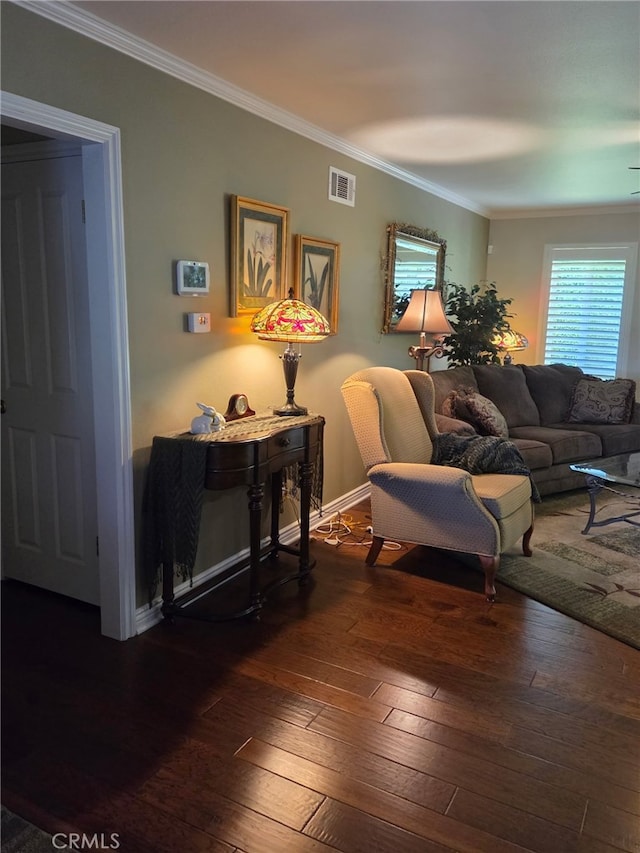 living room featuring crown molding, baseboards, visible vents, and hardwood / wood-style flooring