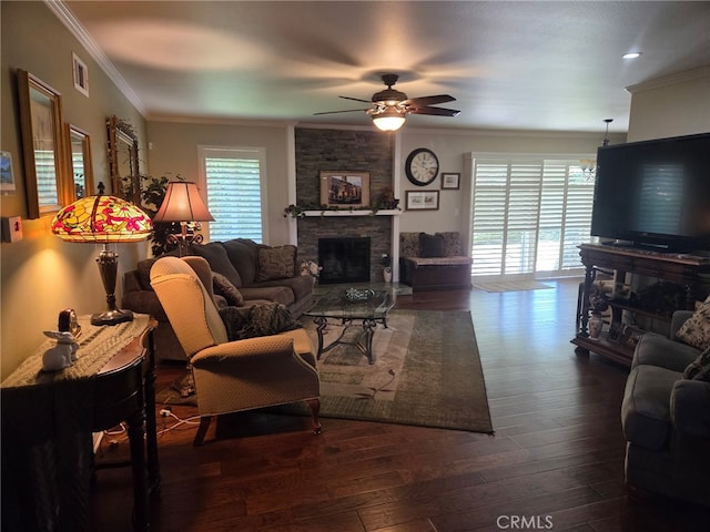 living area with wood-type flooring, a ceiling fan, visible vents, and a stone fireplace