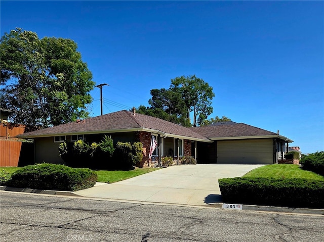 ranch-style house with an attached garage, a front lawn, fence, and concrete driveway
