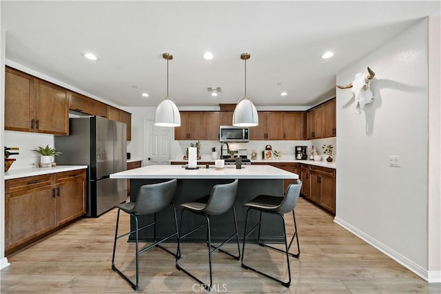 29101 Long Horn Ln, Winchester, CA 92596 - kitchen with a kitchen bar, a center island, light countertops, light wood finished floors, and appliances with stainless steel finishes
