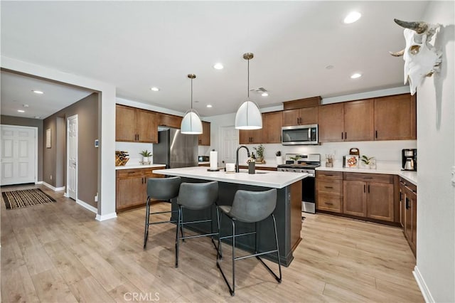 29101 Long Horn Ln, Winchester, CA 92596 - kitchen featuring light countertops, a kitchen breakfast bar, light wood-style floors, and stainless steel appliances