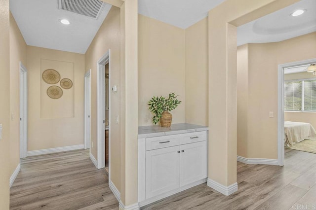 corridor featuring recessed lighting, baseboards, visible vents, and light wood-style flooring