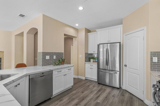 kitchen featuring light stone counters, decorative backsplash, and stainless steel appliances