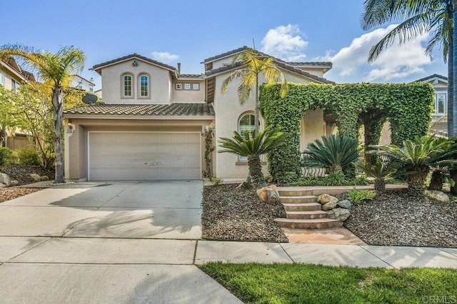 mediterranean / spanish home with stucco siding, an attached garage, driveway, and a tile roof