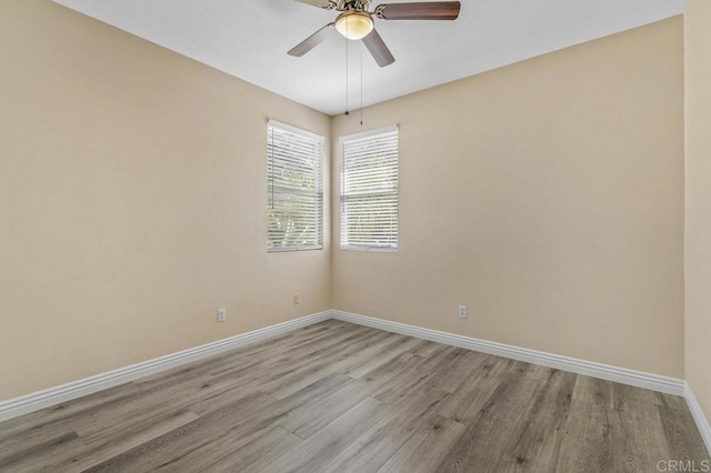 empty room featuring baseboards, ceiling fan, and wood finished floors