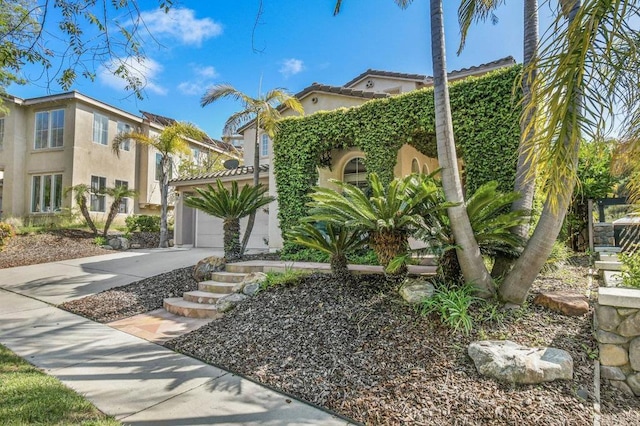 view of front facade featuring concrete driveway, an attached garage, and stucco siding