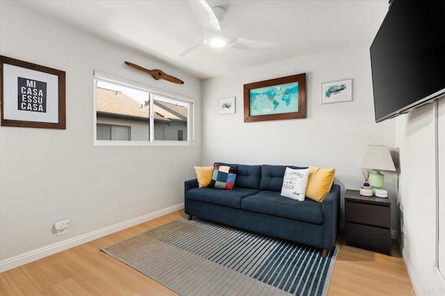 living room with baseboards, a ceiling fan, and wood finished floors