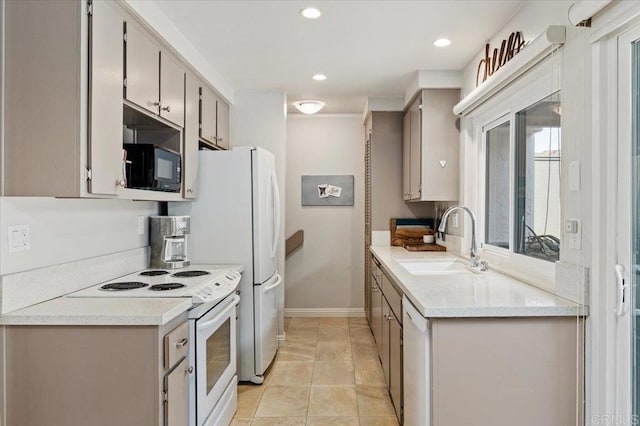 kitchen featuring electric range, black microwave, baseboards, light countertops, and a sink