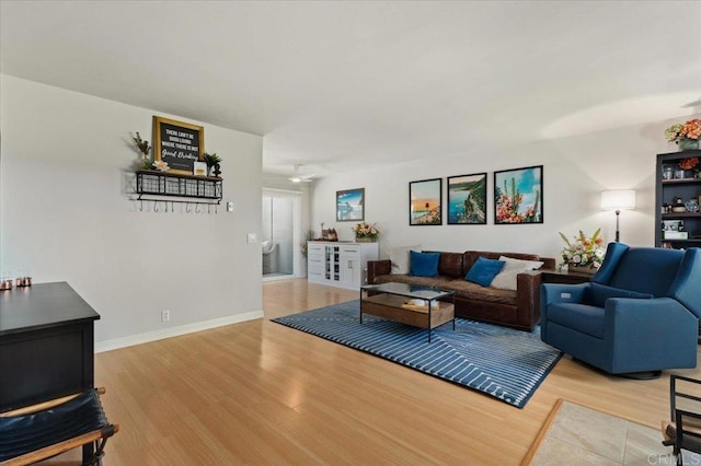 living area with baseboards and wood finished floors