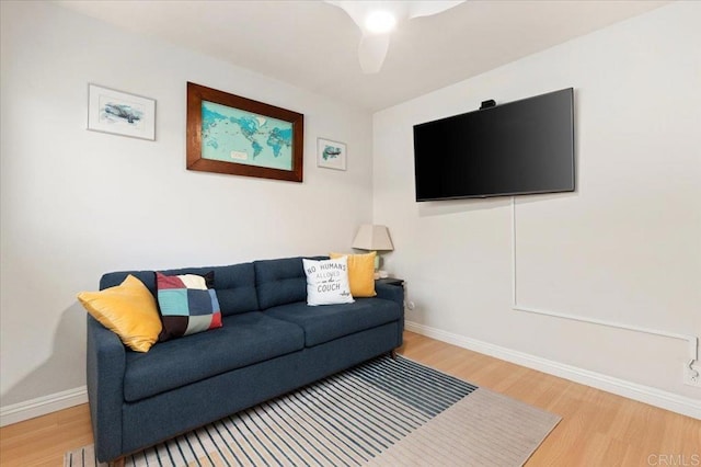 living area featuring baseboards and wood finished floors