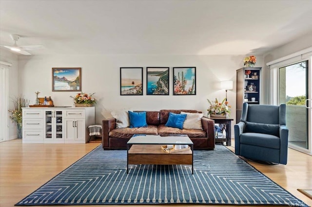 living area featuring a ceiling fan and light wood finished floors