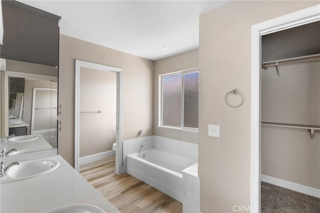 1128 Grass Valley Way, Santa Maria, CA 93454 - bathroom featuring a sink, a walk in closet, toilet, and a bath