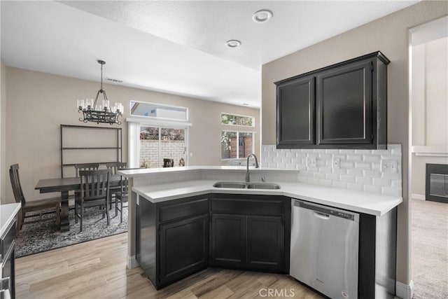 1128 Grass Valley Way, Santa Maria, CA 93454 - kitchen with stainless steel dishwasher, a sink, light countertops, a peninsula, and an inviting chandelier