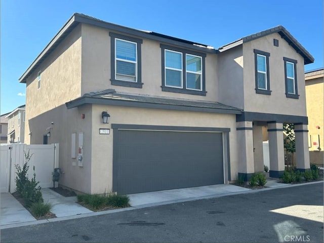 traditional-style home with a garage, fence, and stucco siding