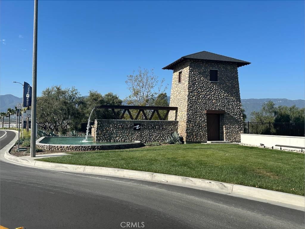 view of side of home with a lawn, a mountain view, and stone siding