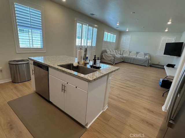 2511 Gunner Ridge Way, Rialto, CA 92377 - kitchen with dishwasher, an island with sink, light wood finished floors, white cabinetry, and light stone counters