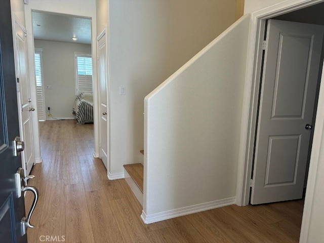 2511 Gunner Ridge Way, Rialto, CA 92377 - hallway with wood finished floors, stairway, and baseboards