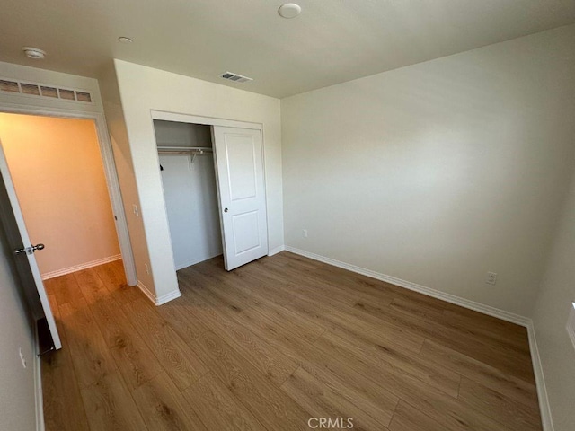 2511 Gunner Ridge Way, Rialto, CA 92377 - unfurnished bedroom featuring wood finished floors, a closet, and baseboards