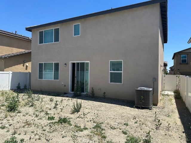 2511 Gunner Ridge Way, Rialto, CA 92377 - rear view of house with central AC unit, a fenced backyard, and stucco siding