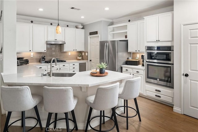27975 Langley Pl, Castaic, CA 91384 - kitchen featuring a sink, appliances with stainless steel finishes, a peninsula, under cabinet range hood, and crown molding