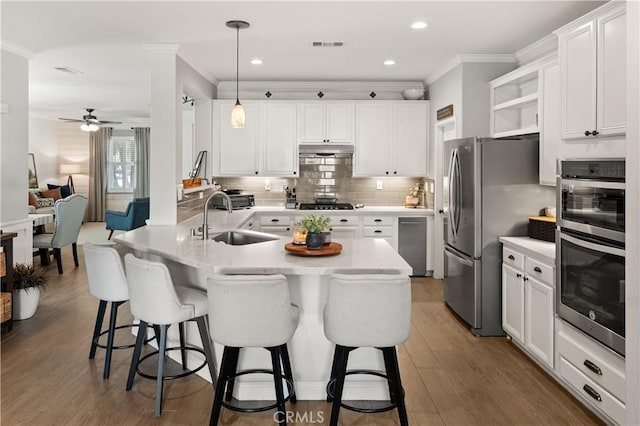 27975 Langley Pl, Castaic, CA 91384 - kitchen featuring stainless steel appliances, a sink, under cabinet range hood, ornamental molding, and ceiling fan