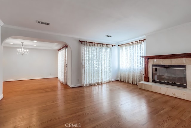 814 S Patton Ave Unit 2, San Pedro, CA 90731 - unfurnished living room with arched walkways, a chandelier, ornamental molding, wood finished floors, and a tiled fireplace