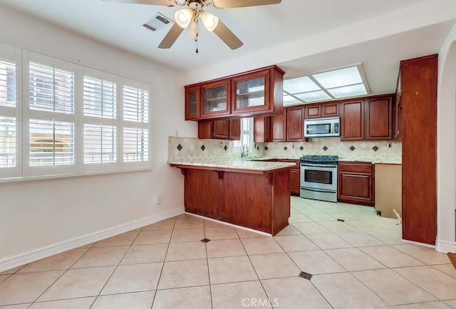 814 S Patton Ave Unit 2, San Pedro, CA 90731 - kitchen with stainless steel appliances, a peninsula, decorative backsplash, and a breakfast bar area